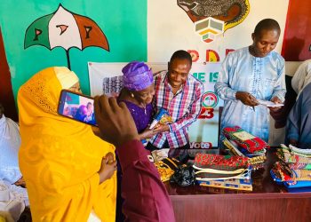 Hon Alex Isaac distributes wrappers to widows and aged women in Zawan B