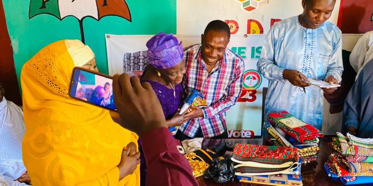 Hon Alex Isaac distributes wrappers to widows and aged women in Zawan B
